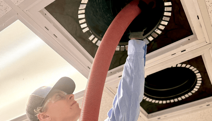 Jackson & Sons technician cleaning a duct system.