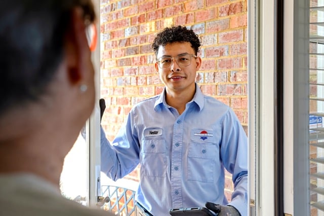 Jackson & Sons HVAC technician greeting a customer at the front door in Eastern NC