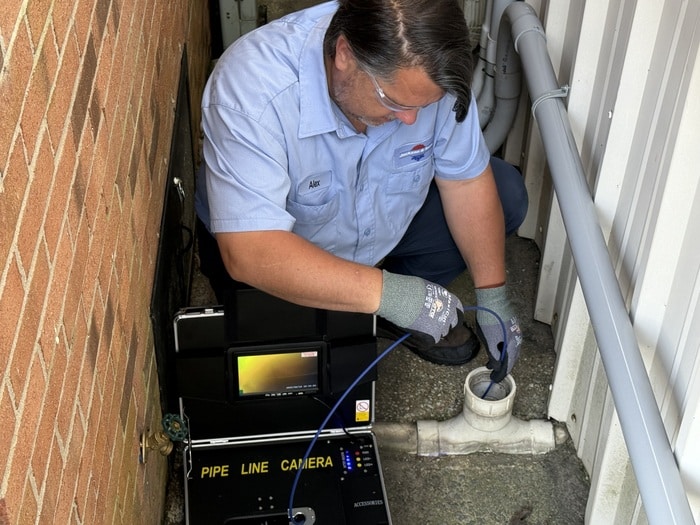 ackson & Sons plumber performing a sewer camera inspection to diagnose pipe issues at a residential property in Eastern NC.