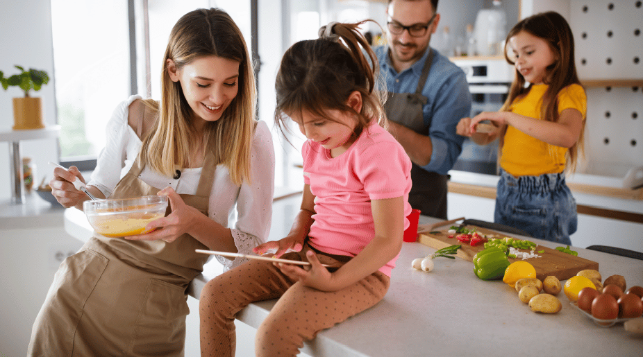 Mother Daughter Looking At Tablet In Kitchen